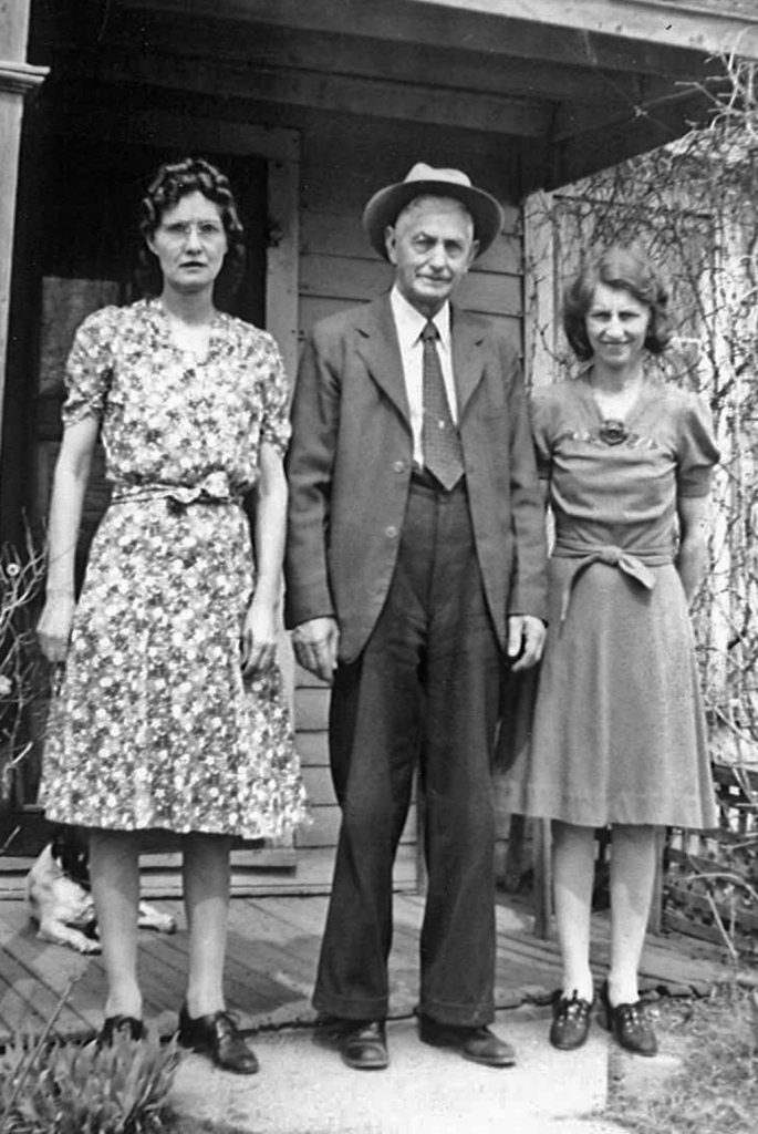 Mrs. Roberts (Grandpa's housekeeper), Grandpa, and his niece Verna Noble Bowhan on the front porch of Grandpa's house, which was built around a train car.